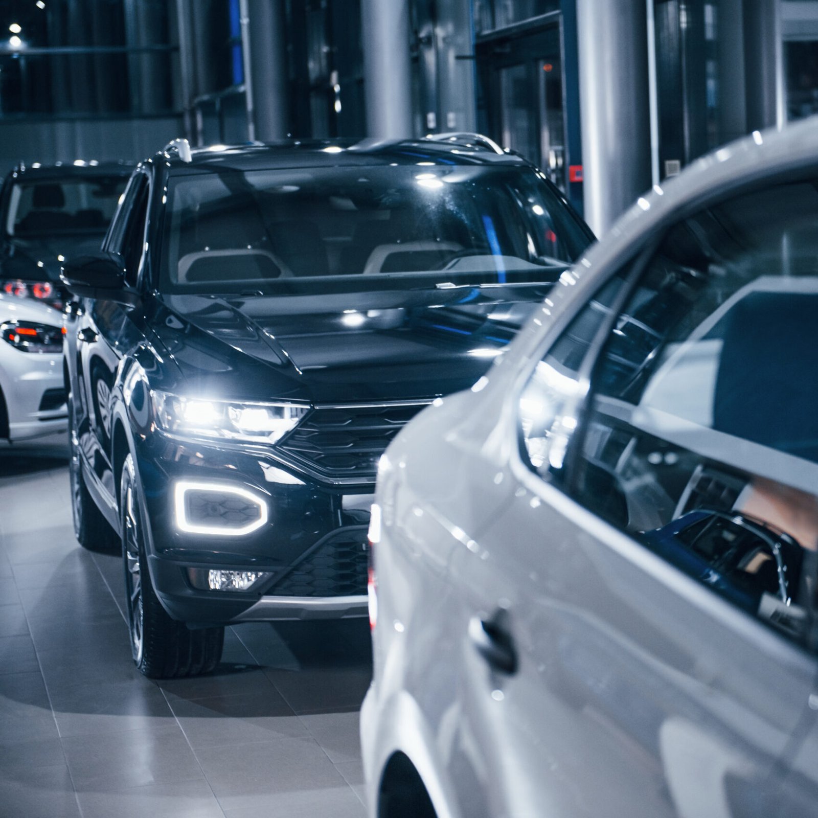 Modern brand new black and white cars parked in the autosalon.